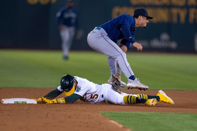 Sep 19, 2023; Oakland, California, USA; Oakland Athletics left fielder Tony Kemp (5) is caught stealing by Seattle Mariners third baseman Josh Rojas (4) during the third inning at Oakland-Alameda County Coliseum. Mandatory Credit: Neville E. Guard-USA TODAY Sports