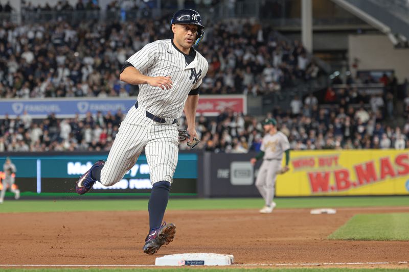 Apr 25, 2024; Bronx, New York, USA; New York Yankees designated hitter Giancarlo Stanton (27) reaches third base on a single by left fielder Alex Verdugo (not pictured) during the fourth inning at Yankee Stadium. Mandatory Credit: Vincent Carchietta-USA TODAY Sports