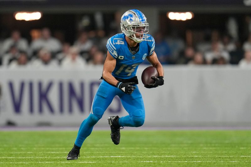 Detroit Lions wide receiver Amon-Ra St. Brown (14) runs with the football after catching a pass during the second half of an NFL football game against the Minnesota Vikings, Sunday, Dec. 24, 2023, in Minneapolis. (AP Photo/Abbie Parr)