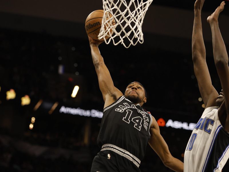 SAN ANTONIO, TX - MARCH 14:  Blake Wesley #14 of the San Antonio Spurs dunks past Bol Bol #10 of the Orlando Magic in the first half at AT&T Center on March 14, 2023 in San Antonio, Texas. NOTE TO USER: User expressly acknowledges and agrees that, by downloading and or using this photograph, User is consenting to terms and conditions of the Getty Images License Agreement. (Photo by Ronald Cortes/Getty Images)