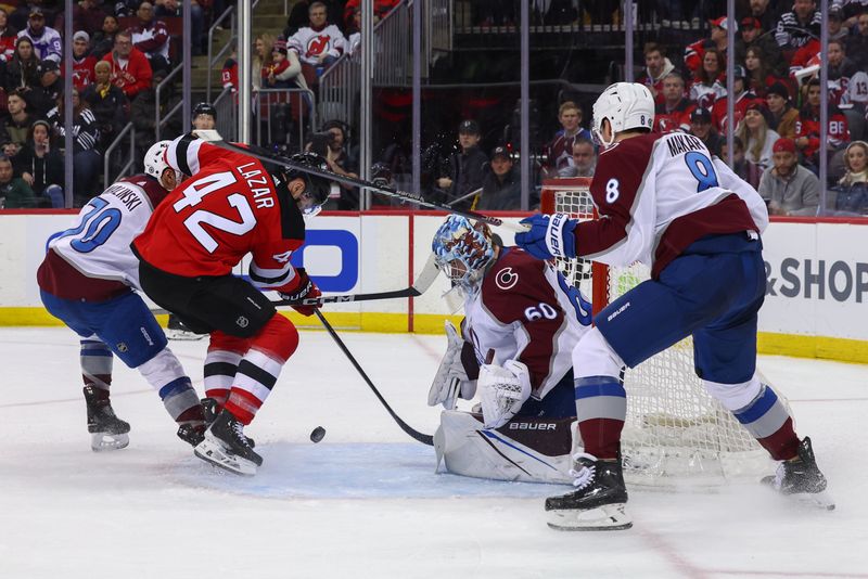 Feb 6, 2024; Newark, New Jersey, USA; Colorado Avalanche goaltender Justus Annunen (60) makes a save on New Jersey Devils center Curtis Lazar (42) during the second period at Prudential Center. Mandatory Credit: Ed Mulholland-USA TODAY Sports