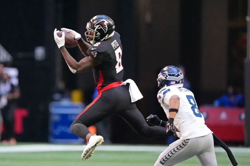 Atlanta Falcons tight end Kyle Pitts (8) makes a catch as Seattle Seahawks cornerback Coby Bryant (8) defends during the first half of an NFL football game, Sunday, Oct. 20, 2024, in Atlanta. (AP Photo/ Mike Stewart )