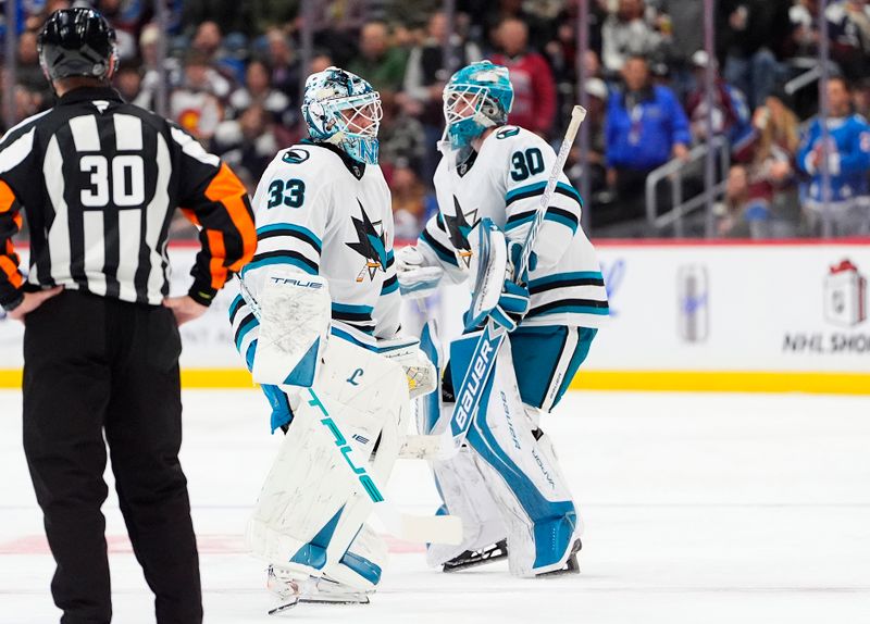 Nov 26, 2025; Denver, Colorado, USA; San Jose Sharks goaltender Alex Nedeljkovic (33) leaves the ice for goaltender Yaroslav Askarov (30) during the second period against the Colorado Avalanche at Ball Arena. Mandatory Credit: Ron Chenoy-Imagn Images