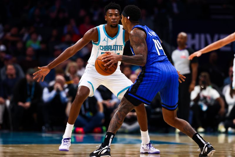 CHARLOTTE, NORTH CAROLINA - NOVEMBER 25: Brandon Miller #24 of the Charlotte Hornets defends Gary Harris #14 of the Orlando Magic during the first half of a basketball game against the Orlando Magic at Spectrum Center on November 25, 2024 in Charlotte, North Carolina. NOTE TO USER: User expressly acknowledges and agrees that, by downloading and or using this photograph, User is consenting to the terms and conditions of the Getty Images License Agreement. (Photo by David Jensen/Getty Images)