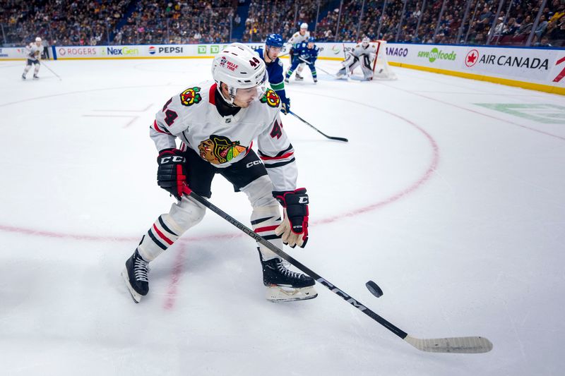 Nov 16, 2024; Vancouver, British Columbia, CAN; Chicago Blackhawks defenseman Wyatt Kaiser (44) handles the puck against the Vancouver Canucks during the first period at Rogers Arena. Mandatory Credit: Bob Frid-Imagn Images