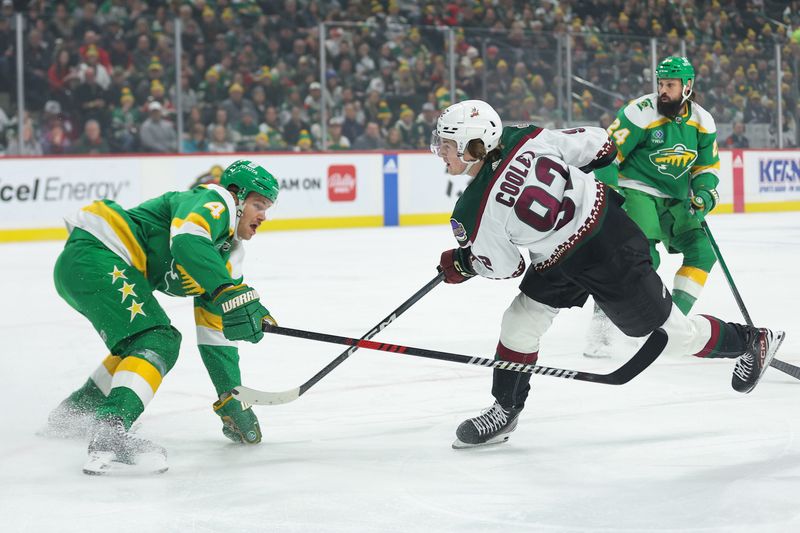 Jan 13, 2024; Saint Paul, Minnesota, USA; Arizona Coyotes center Logan Cooley (92) shoots as Minnesota Wild defenseman Jon Merrill (4) defends during the first period at Xcel Energy Center. Mandatory Credit: Matt Krohn-USA TODAY Sports