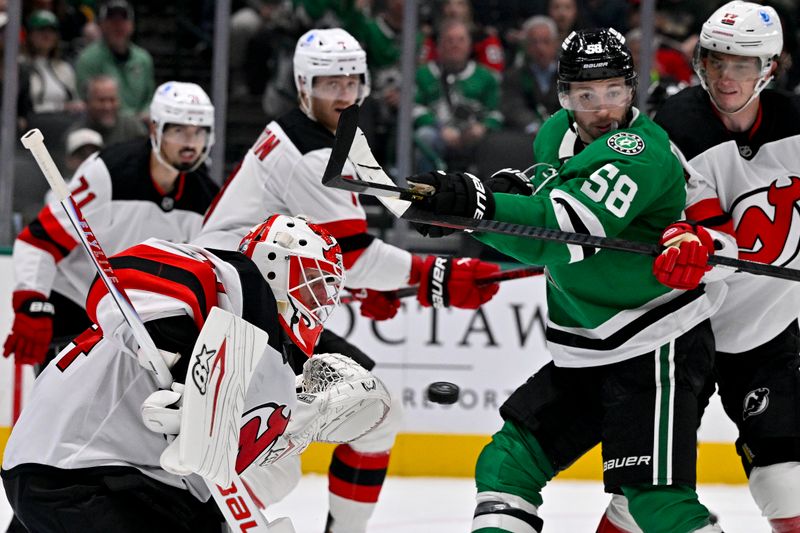 Mar 24, 2026; Dallas, Texas, USA; Dallas Stars left wing Michael Bunting (58) attempts to redirect the puck past New Jersey Devils goaltender Jake Allen (34) during the second period at the American Airlines Center. Mandatory Credit: Jerome Miron-Imagn Images