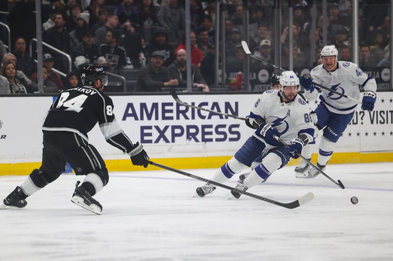 Mar 23, 2024; Los Angeles, California, USA; Tampa Bay Lighting right wing Nikita Kucherov (86) moves the puck as Los Angeles Kings defensemen Vladislav Gavrikov (84) defends during the first period of an NHL hockey game at Crypto.com Arena. Mandatory Credit: Yannick Peterhans-USA TODAY Sports