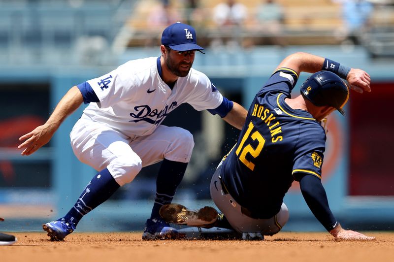 Jul 7, 2024; Los Angeles, California, USA; Los Angeles Dodgers outfielder Chris Taylor (3) tags out Milwaukee Brewers first baseman Rhys Hoskins (12) during the first inning at Dodger Stadium. Mandatory Credit: Jason Parkhurst-USA TODAY Sports