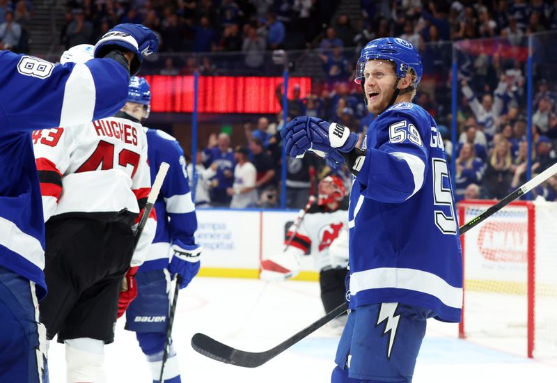 Nov 18, 2025; Tampa, Florida, USA; Tampa Bay Lightning center Jake Guentzel (59) is congratulated  after he scores a goal for a hat trick against the New Jersey Devils during the third period at Benchmark International Arena. Mandatory Credit: Kim Klement Neitzel-Imagn Images