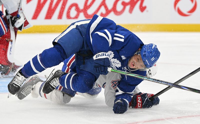 Sep 26, 2024; Toronto, Ontario, CAN;  Toronto Maple Leafs forward Max Domi (11) falls to the ice after colliding with Montreal Canadiens defenseman Jayden Strubel (47) in the third period at Scotiabank Arena. Mandatory Credit: Dan Hamilton-Imagn Images