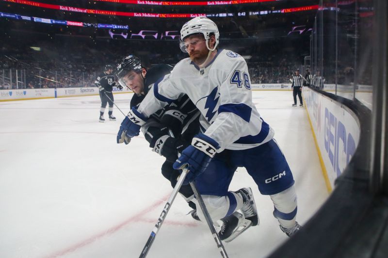 Mar 23, 2024; Los Angeles, California, USA; Tampa Bay Lighting defensemen Nick Perbix (48) and Los Angeles Kings right wing Alex Laferriere (78) chase the puck during the third period of an NHL hockey game at Crypto.com Arena. Mandatory Credit: Yannick Peterhans-USA TODAY Sports