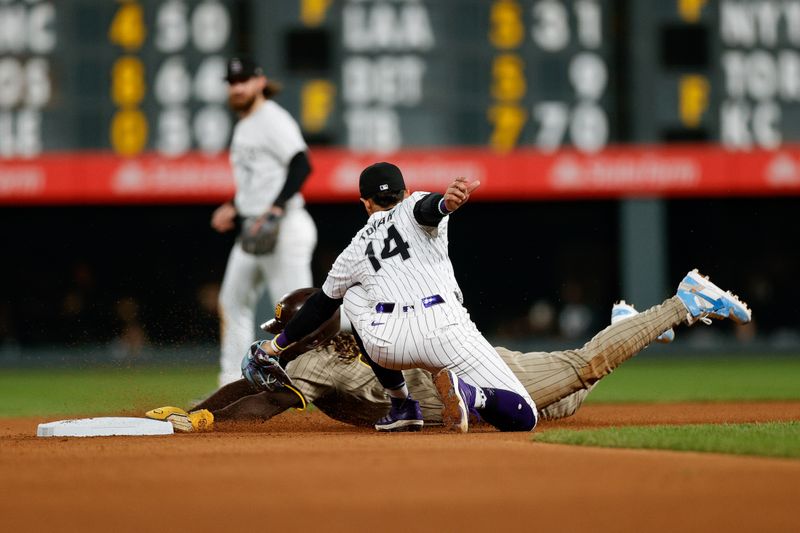 Apr 24, 2024; Denver, Colorado, USA; San Diego Padres right fielder Fernando Tatis Jr. (23) is tagged out attempting to steal second against Colorado Rockies shortstop Ezequiel Tovar (14) in the seventh inning at Coors Field. Mandatory Credit: Isaiah J. Downing-USA TODAY Sports