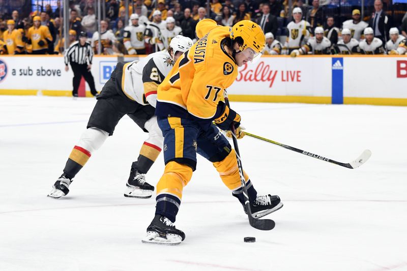 Mar 26, 2024; Nashville, Tennessee, USA; Nashville Predators right wing Luke Evangelista (77) skates with the puck past Vegas Golden Knights center Brett Howden (21) during the first period at Bridgestone Arena. Mandatory Credit: Christopher Hanewinckel-USA TODAY Sports