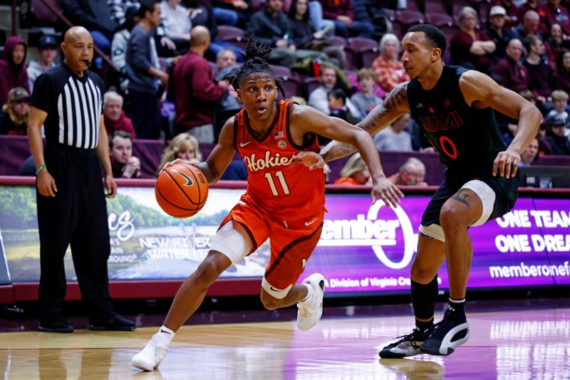 Jan 4, 2025; Blacksburg, Virginia, USA; Virginia Tech Hokies guard Ben Hammond (11) drives to the basket against Miami Hurricanes guard Matthew Cleveland (0) during the first half at Cassell Coliseum. Mandatory Credit: Peter Casey-Imagn Images