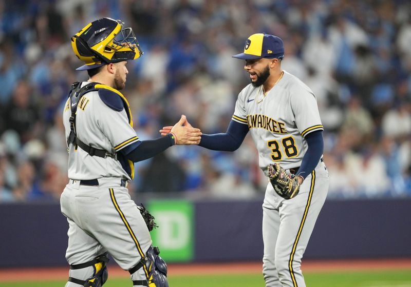 May 31, 2023; Toronto, Ontario, CAN; Milwaukee Brewers relief pitcher Devin Williams (38) celebrates a win with catcher Victor Caratini (7) against the Toronto Blue Jays at the end of the ninth inning at Rogers Centre. Mandatory Credit: Nick Turchiaro-USA TODAY Sports