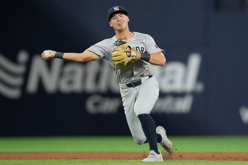 Apr 16, 2024; Toronto, Ontario, CAN; New York Yankees shortstop Anthony Volpe (11) throws out Toronto Blue Jays third baseman Ernie Clement (not pictured) at first base during the seventh inning at Rogers Centre. Mandatory Credit: John E. Sokolowski-USA TODAY Sports