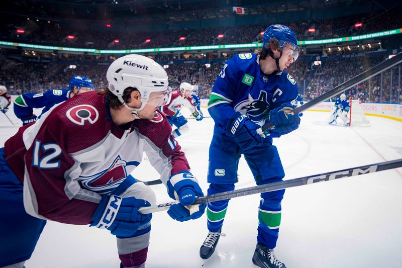 Mar 13, 2024; Vancouver, British Columbia, CAN;  Colorado Avalanche forward Brandon Duhaime (12) battles with Vancouver Canucks defenseman Quinn Hughes (43) in the first period at Rogers Arena. Mandatory Credit: Bob Frid-USA TODAY Sports