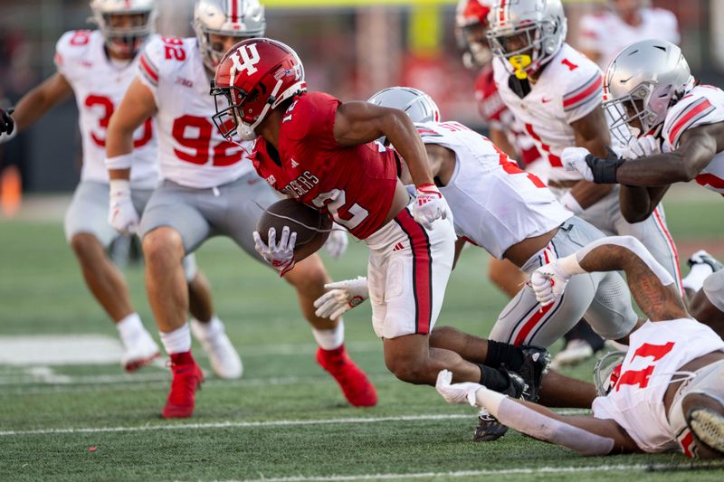 Sep 2, 2023; Bloomington, Indiana, USA; Indiana Hoosiers running back Jaylin Lucas (12) evades tackle by Ohio State Buckeyes linebacker C.J. Hicks (11) during the second half at Memorial Stadium. Mandatory Credit: Marc Lebryk-USA TODAY Sports