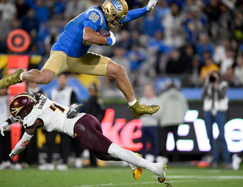 Nov 11, 2023; Pasadena, California, USA;  UCLA Bruins tight end Moliki Matavao (88) leaps over Arizona State Sun Devils defensive back Shamari Simmons (7) after making a catch during the first half at the Rose Bowl. Mandatory Credit: Alex Gallardo-USA TODAY Sports