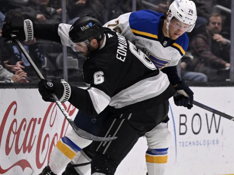 Mar 5, 2025; Los Angeles, California, USA;  Los Angeles Kings defenseman Joel Edmundson (6) checks St. Louis Blues center Zack Bolduc (76) from the puck during the third period at Crypto.com Arena. Mandatory Credit: Alex Gallardo-Imagn Images