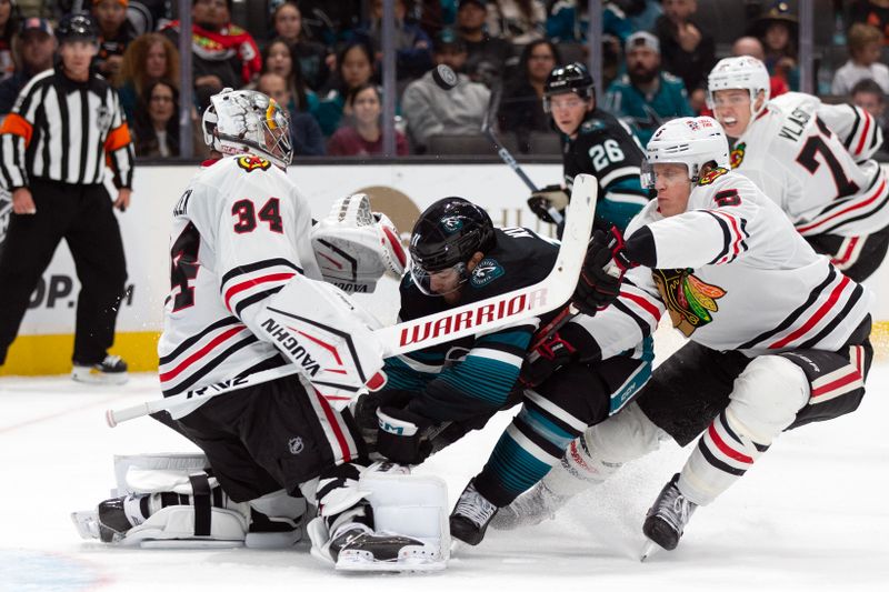 Oct 31, 2024; San Jose, California, USA; San Jose Sharks center Luke Kunin (11) collides with Chicago Blackhawks goaltender Petr Mrazek (34) during the second period at SAP Center at San Jose. Mandatory Credit: D. Ross Cameron-Imagn Images