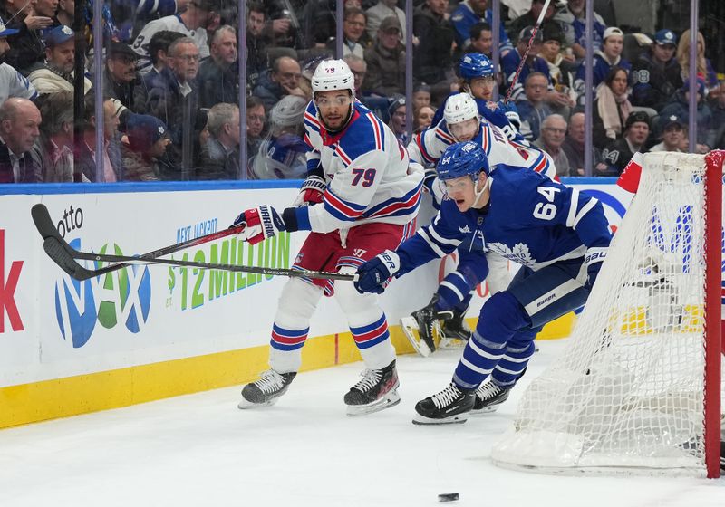 Dec 19, 2023; Toronto, Ontario, CAN; Toronto Maple Leafs center David Kampf (64) and New York Rangers defenseman K'Andre Miller (79) battle for the puck behind the net during the first period at Scotiabank Arena. Mandatory Credit: Nick Turchiaro-USA TODAY Sports