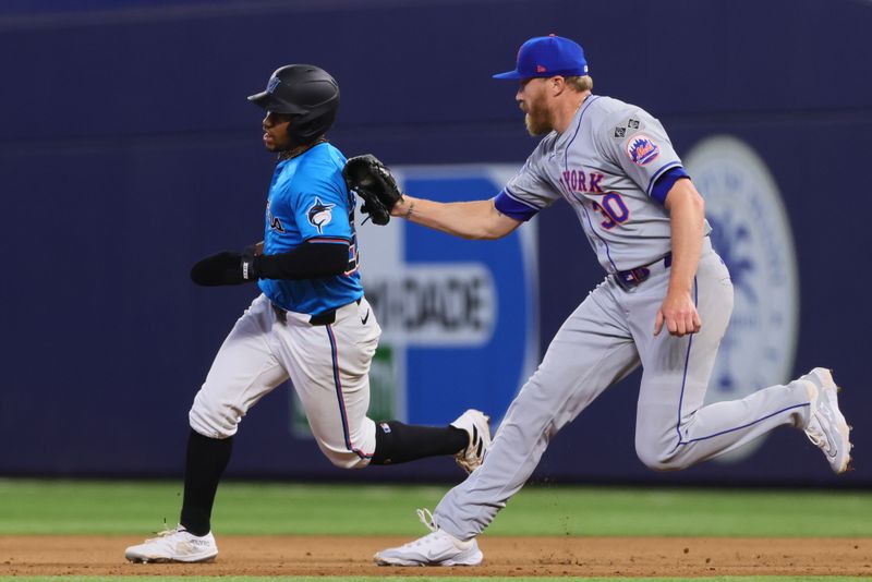 Jul 21, 2024; Miami, Florida, USA; New York Mets relief pitcher Jake Diekman (30) tags out Miami Marlins second baseman Xavier Edwards (63) during a steal attempt in the eighth inning at loanDepot Park. Mandatory Credit: Sam Navarro-USA TODAY Sports