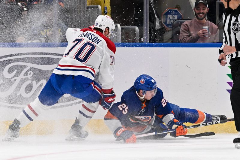 Apr 11, 2024; Elmont, New York, USA; New York Islanders defenseman Sebastian Aho (25) falls to the ice against Montreal Canadiens left wing Tanner Pearson (70) during the first period at UBS Arena. Mandatory Credit: Dennis Schneidler-USA TODAY Sports