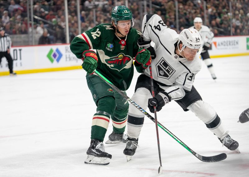 Feb 21, 2023; Saint Paul, Minnesota, USA; Minnesota Wild left wing Matt Boldy (12) and Los Angeles Kings right wing Arthur Kaliyev (34) fight for position after a faceoff in the third period at Xcel Energy Center. Mandatory Credit: Matt Blewett-USA TODAY Sports