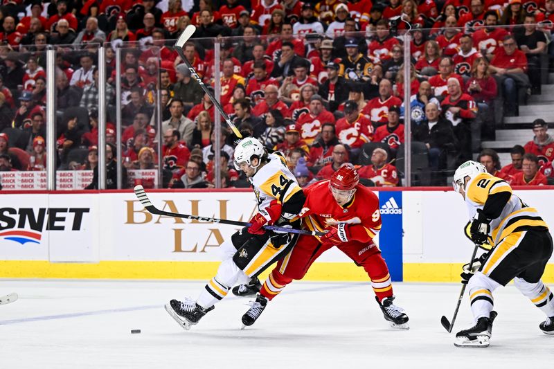 Mar 2, 2024; Calgary, Alberta, CAN; Pittsburgh Penguins center Jonathan Gruden (44) goes airborne while battling for the puck against Calgary Flames left wing Andrei Kuzmenko (96) during the first period at Scotiabank Saddledome. Mandatory Credit: Brett Holmes-USA TODAY Sports
