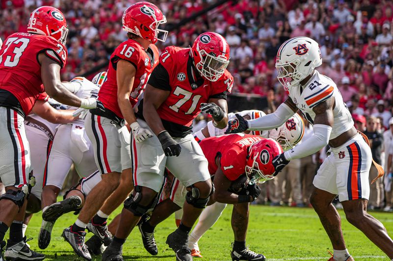 Oct 5, 2024; Athens, Georgia, USA; Georgia Bulldogs running back Trevor Etienne (1) scores a touchdown under Auburn Tigers safety Caleb Wooden (21) during the first quarter at Sanford Stadium. Mandatory Credit: Dale Zanine-Imagn Images