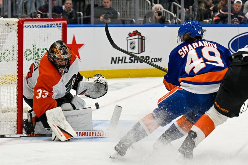 Nov 28, 2025; Elmont, New York, USA; Philadelphia Flyers goaltender Samuel Ersson (33) makes a save on New York Islanders right wing Max Shabanov (49) during the second period at UBS Arena. Mandatory Credit: Dennis Schneidler-Imagn Images