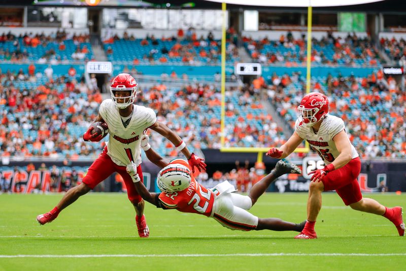 Nov 18, 2023; Miami Gardens, Florida, USA; Louisville Cardinals wide receiver Jamari Thrash (1) runs with the football for a touchdown against Miami Hurricanes defensive back Jaden Davis (22) during the fourth quarter at Hard Rock Stadium. Mandatory Credit: Sam Navarro-USA TODAY Sports