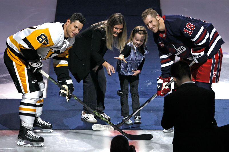 Oct 20, 2024; Winnipeg, Manitoba, CAN; Retired Winnipeg Jet Bryan Little  with Pittsburgh Penguins center Sidney Crosby (87) as Little’s wife and daughter do a ceremonial puck drop at Canada Life Centre. Mandatory Credit: James Carey Lauder-Imagn Images