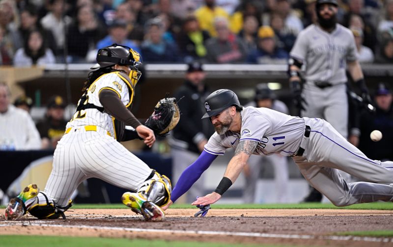 May 13, 2024; San Diego, California, USA; Colorado Rockies right fielder Jake Cave (11) dives home to score a run ahead of the throw to San Diego Padres catcher Luis Campusano (12) during the fourth inning at Petco Park. Mandatory Credit: Orlando Ramirez-USA TODAY Sports