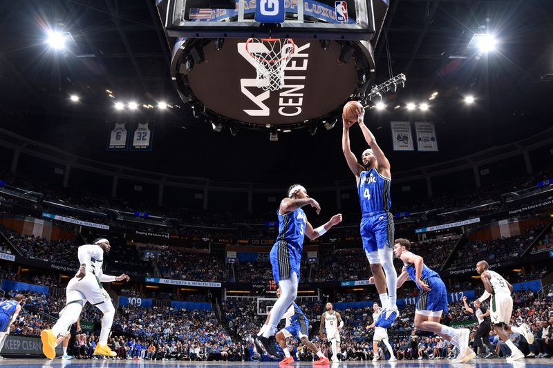 ORLANDO, FL - APRIL 14: Jalen Suggs #4 of the Orlando Magic grabs a rebound during the game against the Milwaukee Bucks on April 14, 2024 at Kia Center in Orlando, Florida. NOTE TO USER: User expressly acknowledges and agrees that, by downloading and or using this photograph, User is consenting to the terms and conditions of the Getty Images License Agreement. Mandatory Copyright Notice: Copyright 2024 NBAE (Photo by Fernando Medina/NBAE via Getty Images)