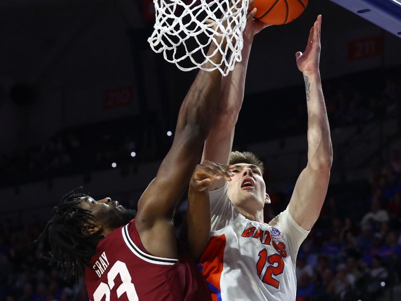 Jan 25, 2023; Gainesville, Florida, USA; Florida Gators forward Colin Castleton (12) shoots over South Carolina Gamecocks forward Gregory Jackson II (23) during the second half at Exactech Arena at the Stephen C. O'Connell Center. Mandatory Credit: Kim Klement-USA TODAY Sports