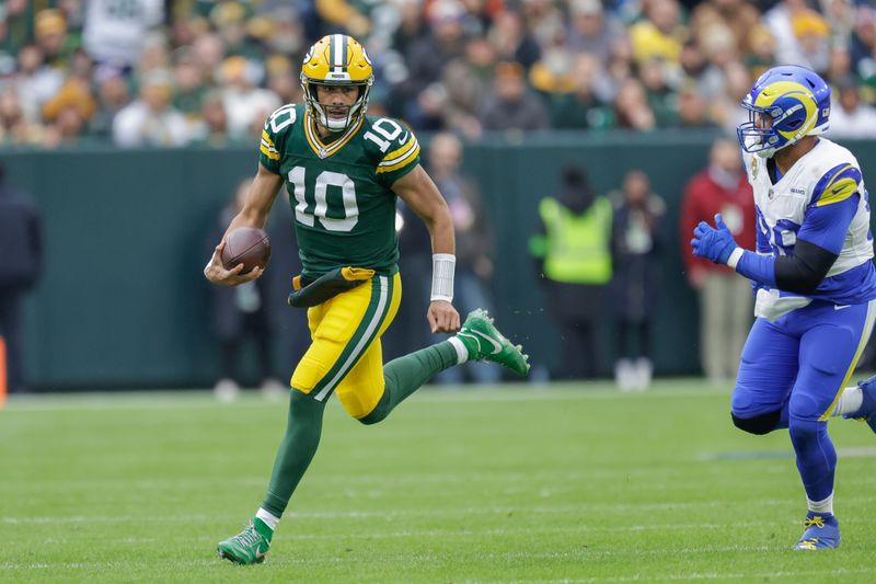 Green Bay Packers quarterback Jordan Love (10) is chased out of the pocket by Los Angeles Rams defensive tackle Aaron Donald (99) during an NFL football game between the Green Bay Packers and Los Angeles Rams Sunday, Nov. 5, 2023, in Green Bay, Wis. (AP Photo/Matt Ludtke)