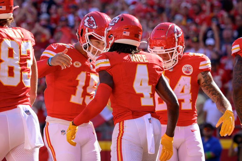 Kansas City Chiefs quarterback Patrick Mahomes (15) and Kansas City Chiefs wide receiver Skyy Moore (24) congratulate Kansas City Chiefs wide receiver Rashee Rice (4) on his touchdown against the Chicago Bears during the first half of an NFL football game, Sunday, Sept. 24, 2023 in Kansas City, Mo. (AP Photo/Reed Hoffmann)