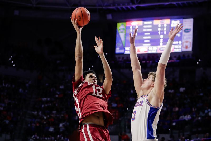 Feb 28, 2026; Gainesville, Florida, USA; Arkansas Razorbacks forward Malique Ewin (12) shoots against Florida Gators center Micah Handlogten (3) during the first half at Exactech Arena at the Stephen C. O'Connell Center. Mandatory Credit: Travis Register-Imagn Images