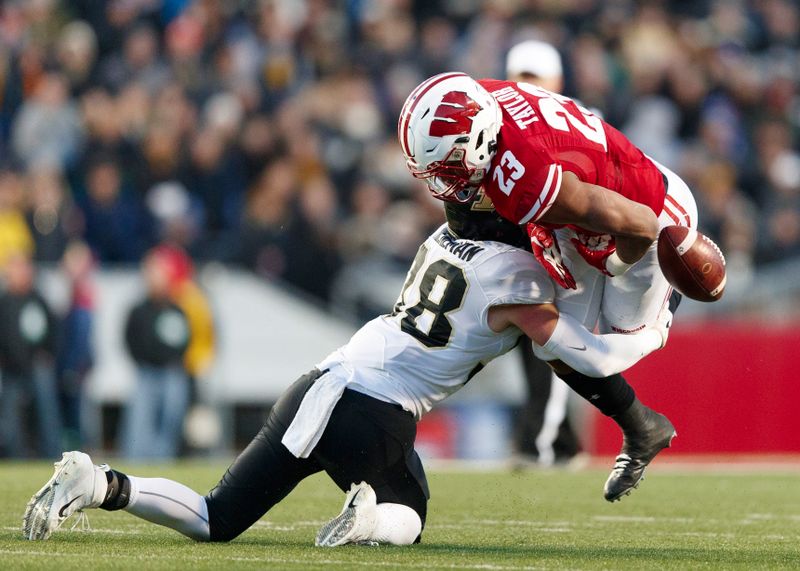 Nov 23, 2019; Madison, WI, USA; Purdue Boilermakers safety Brennan Thieneman (38) causes Wisconsin Badgers running back Jonathan Taylor (23) to fumble during the second quarter at Camp Randall Stadium. Mandatory Credit: Jeff Hanisch-USA TODAY Sports