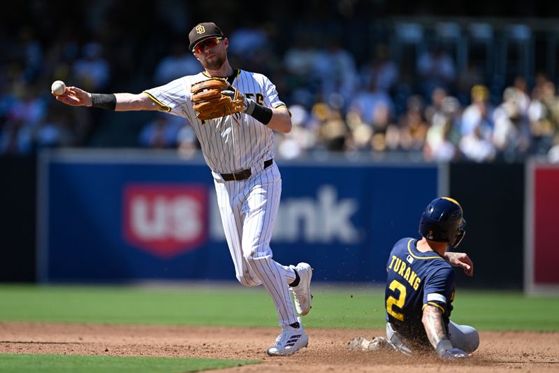 Sep 24, 2025; San Diego, California, USA; San Diego Padres second baseman Jake Cronenworth (9) throws to first base but canít turn the double play as Milwaukee Brewers second baseman Brice Turang (2) slides into second base during the third inning at Petco Park. Mandatory Credit: Denis Poroy-Imagn Images