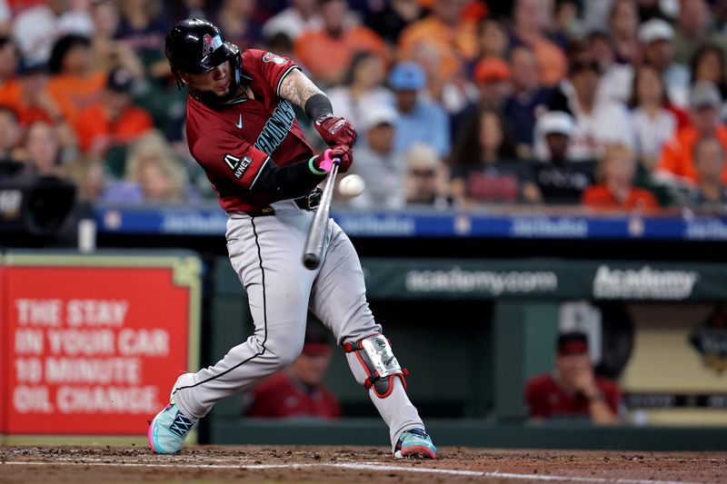 Sep 7, 2024; Houston, Texas, USA; Arizona Diamondbacks catcher Jose Herrera (11) hits an RBI sacrifice fly to right field against the Houston Astros during the second inning at Minute Maid Park. Mandatory Credit: Erik Williams-Imagn Images