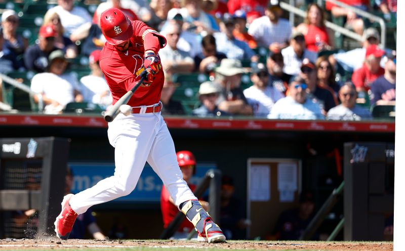 Mar 2, 2023; Jupiter, Florida, USA; St. Louis Cardinals designated hitter Nolan Arenado (28) singles in the second inning against the Houston Astros at Roger Dean Stadium. Mandatory Credit: Rhona Wise-USA TODAY Sports