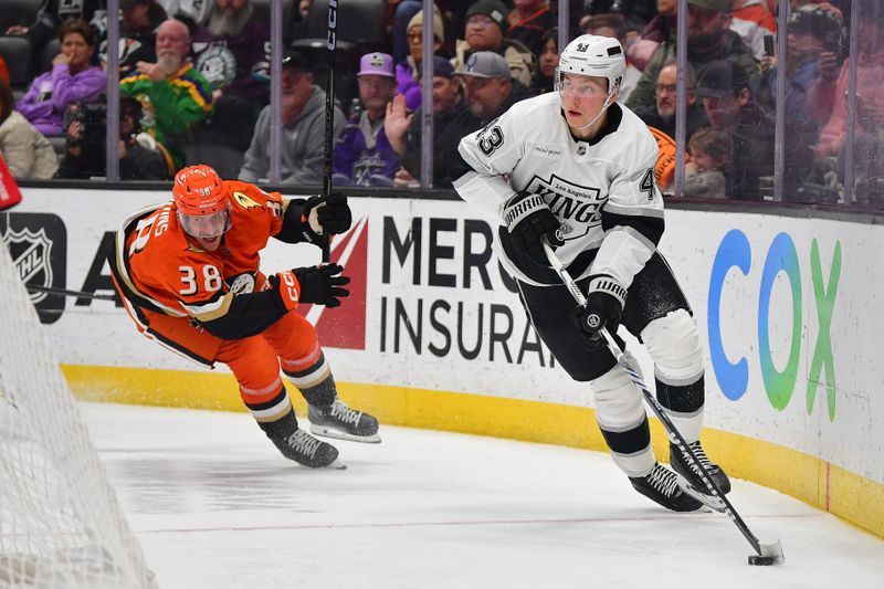 Nov 29, 2024; Anaheim, California, USA; Los Angeles Kings defenseman Jacob Moverare (43) moves the puck ahead of Anaheim Ducks center Jansen Harkins (38) during the second period at Honda Center. Mandatory Credit: Gary A. Vasquez-Imagn Images