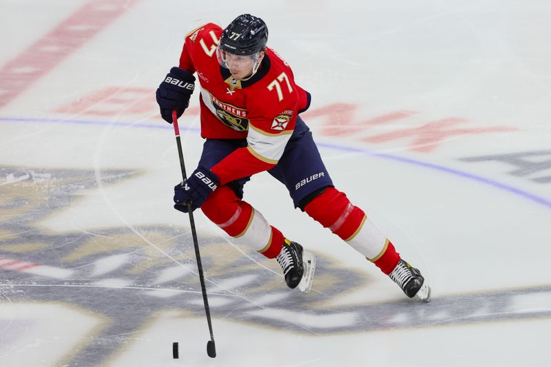 Jan 13, 2024; Sunrise, Florida, USA; Florida Panthers defenseman Niko Mikkola (77) moves the puck against the New Jersey Devils during the third period at Amerant Bank Arena. Mandatory Credit: Sam Navarro-USA TODAY Sports