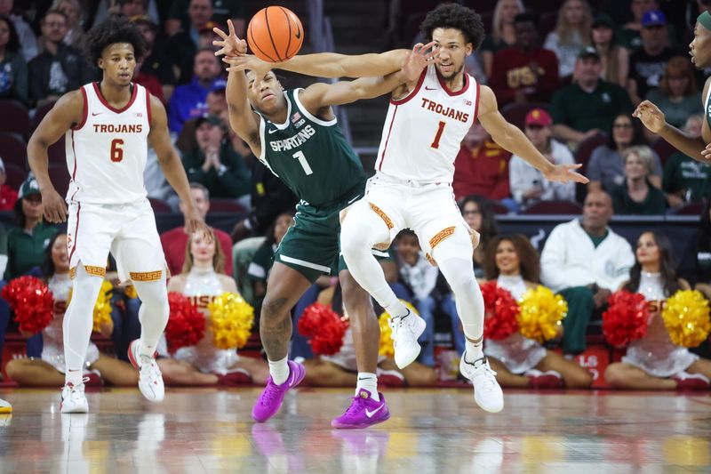 Feb 1, 2025; Los Angeles, California, USA;  USC Trojans guard Desmond Claude (1) battles Michigan State Spartans guard Jeremy Fears Jr. (1) for control of the ball during the first half at Galen Center. Mandatory Credit: William Navarro-Imagn Images