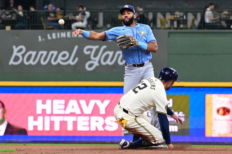 Apr 30, 2024; Milwaukee, Wisconsin, USA; Tampa Bay Rays second baseman Amed Rosario (10) attempts a double play after forcing out Milwaukee Brewers first baseman Rhys Hoskins (12) in the first inning at American Family Field. Mandatory Credit: Benny Sieu-USA TODAY Sports