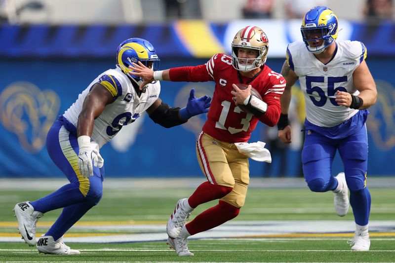 San Francisco 49ers quarterback Brock Purdy (13) runs against Los Angeles Rams defensive tackle Kobie Turner, left, and defensive tackle Braden Fiske (55) during the second half of an NFL football game, Sunday, Sept. 22, 2024, in Inglewood, Calif. (AP Photo/Ryan Sun)